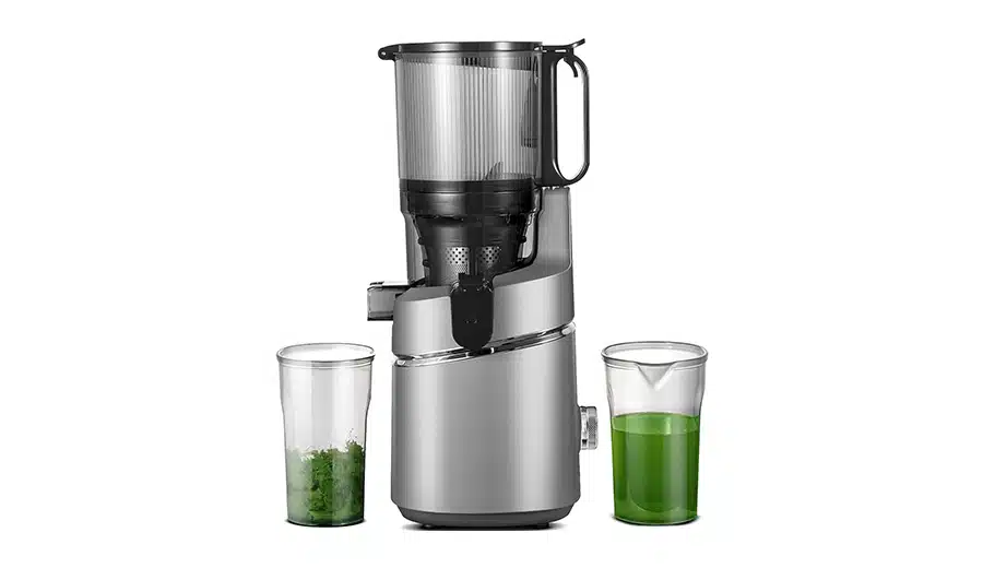 a blender with a glass of green liquid