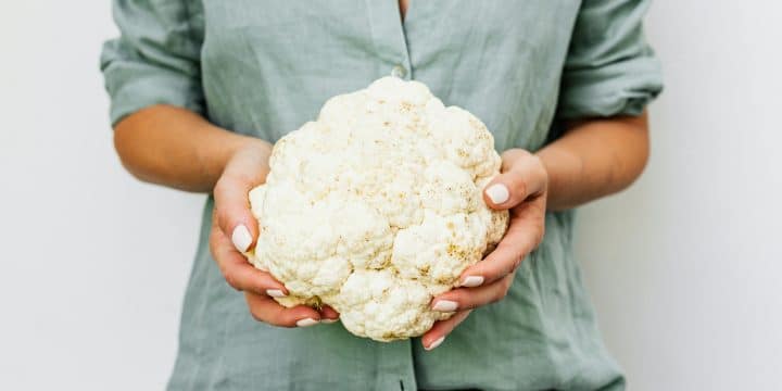 a person holding a cauliflower