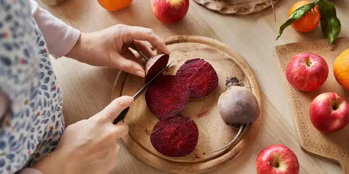 a person slicing beets on a cutting board